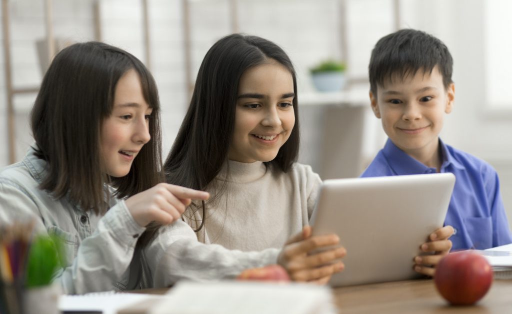 Children watching videos on digital tablet in class